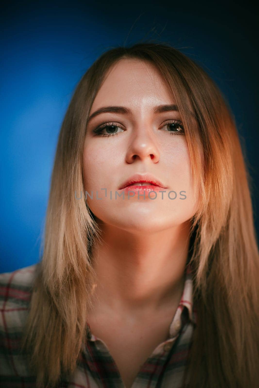 portrait smiling girl on blue background in studio.