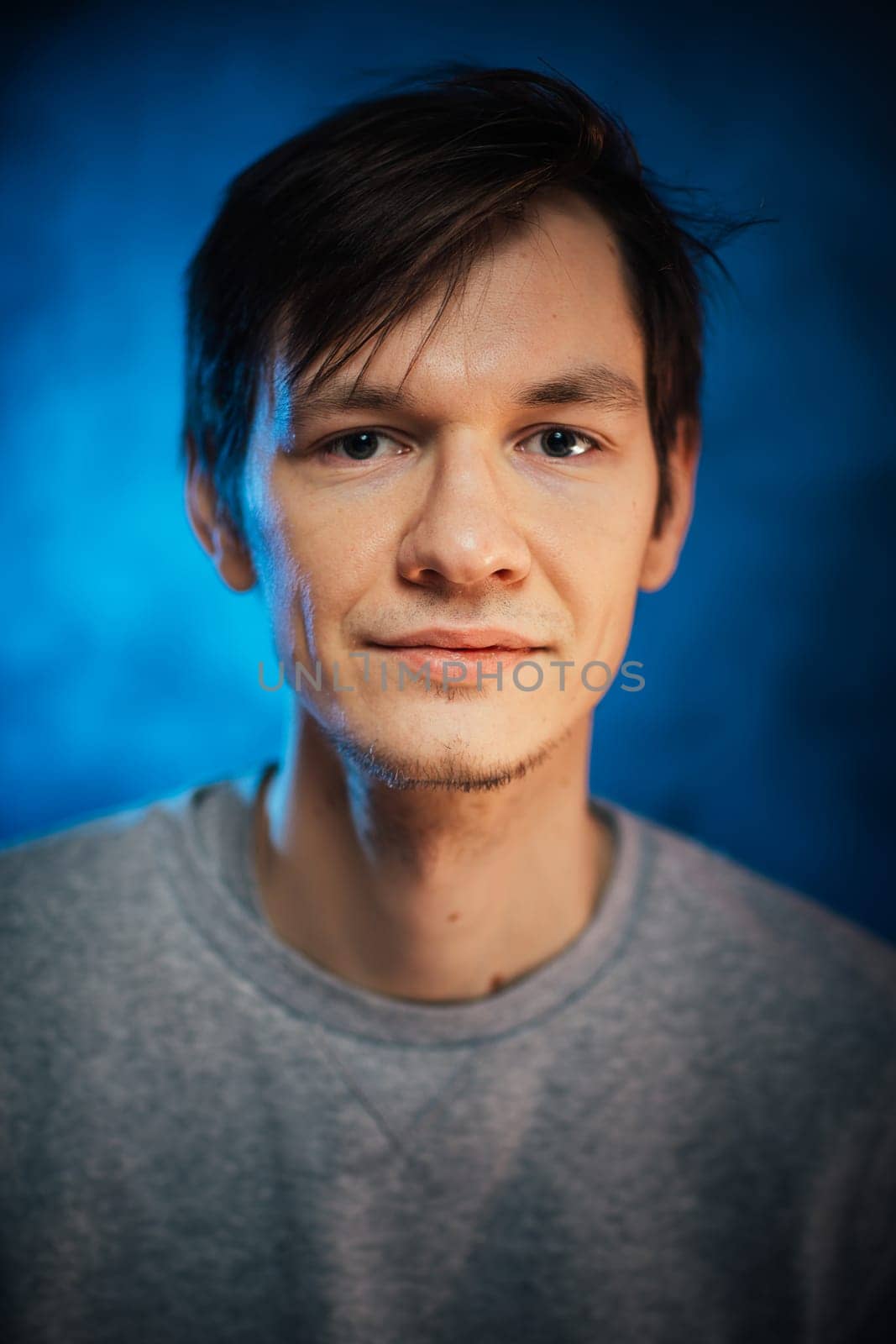 portrait emotional young man on blue background.