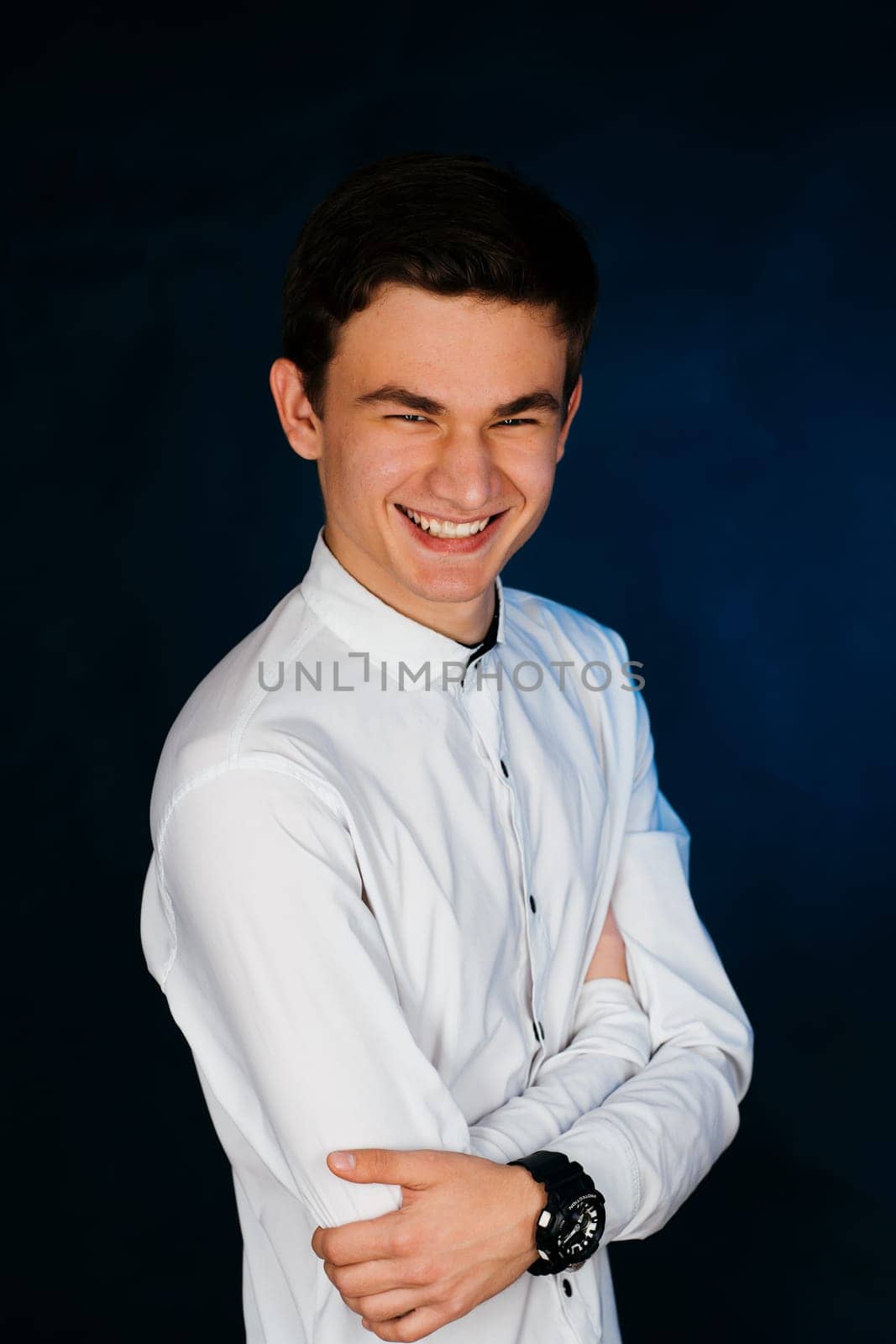 young brunette guy in a white shirt.