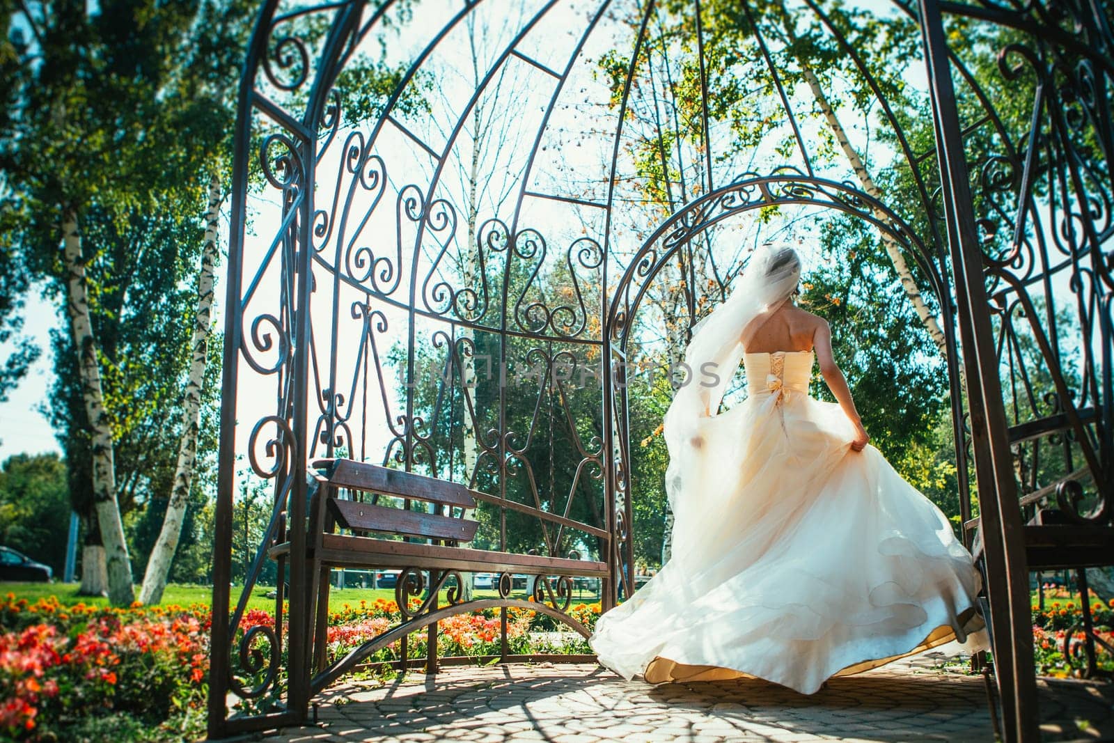 Young beautiful bride standing in a park gazebo
