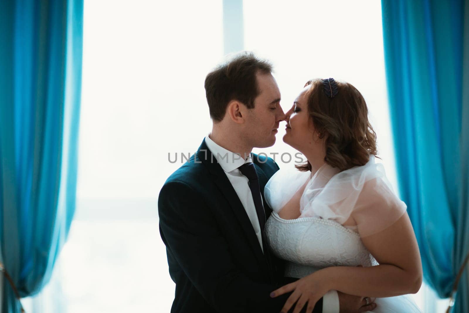 young bride and groom couple in a bright studio photo.