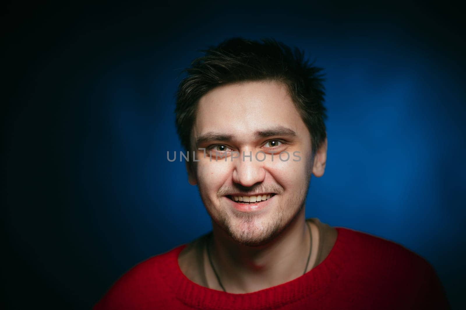 emotional young man photo in studio on blue background