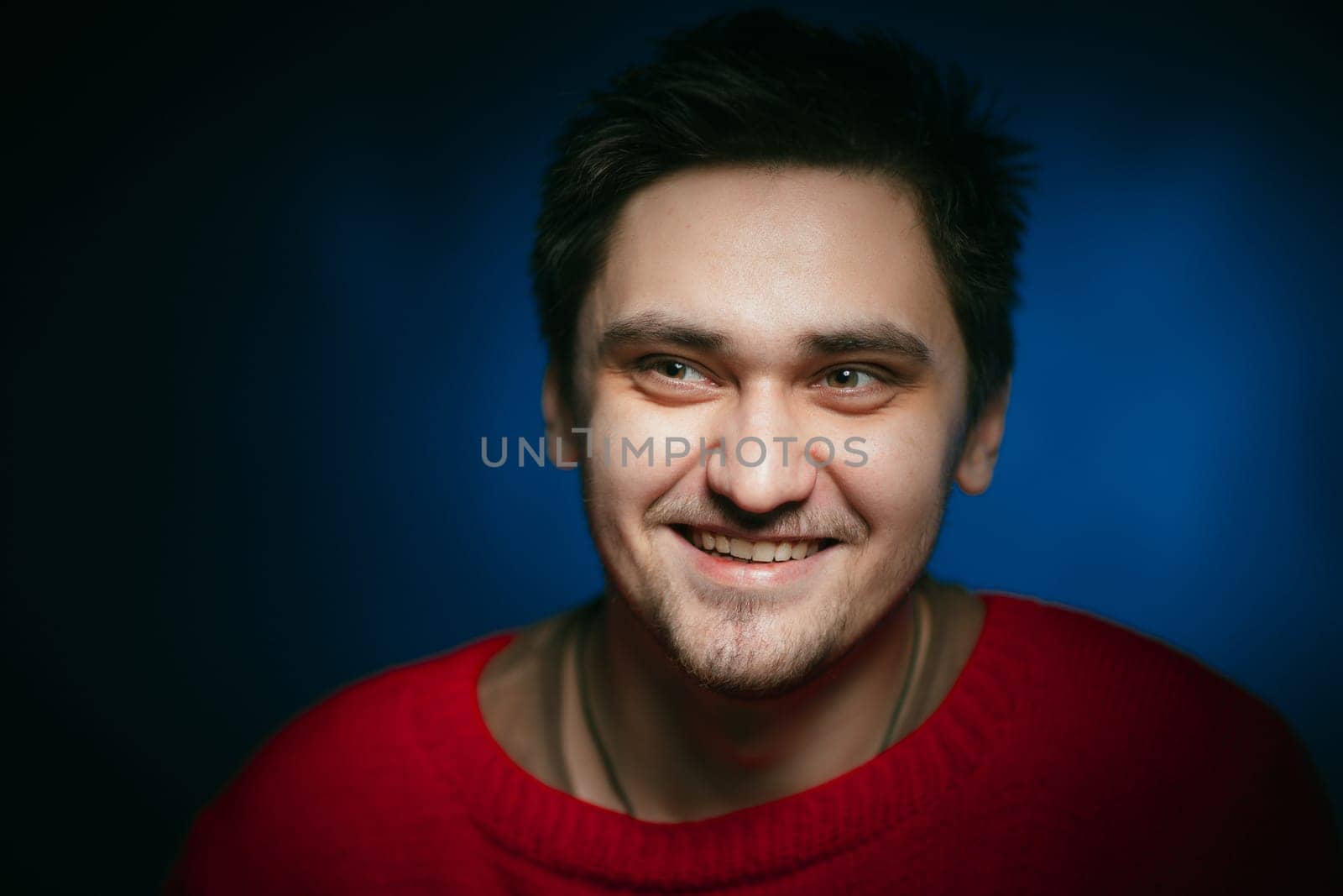 emotional young man photo in studio on blue background