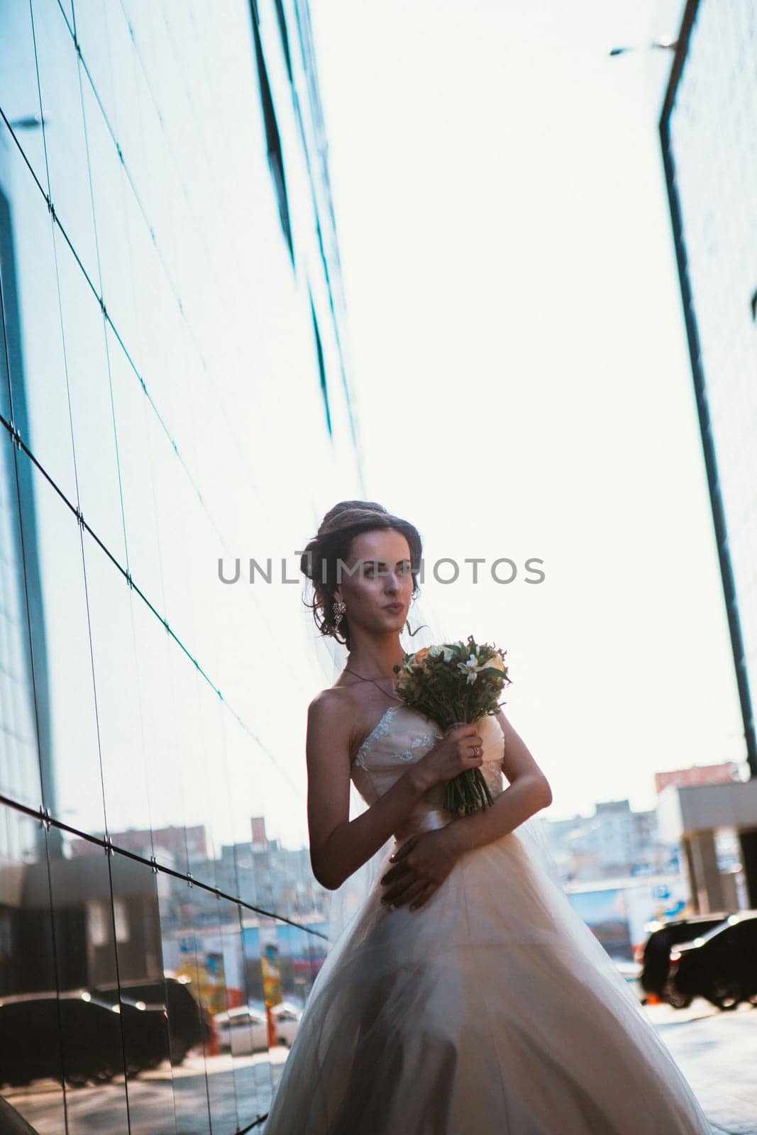Bride and bouquet on backround mirror buildings