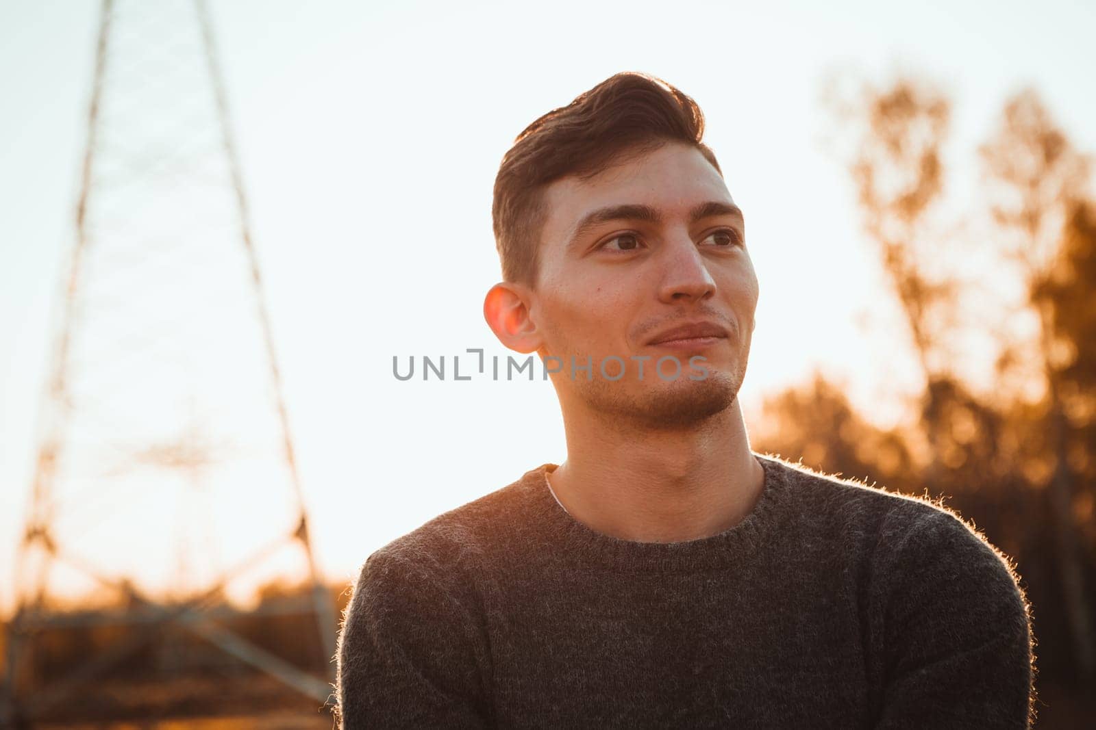 portrait of a guy in the field on a sunset background.