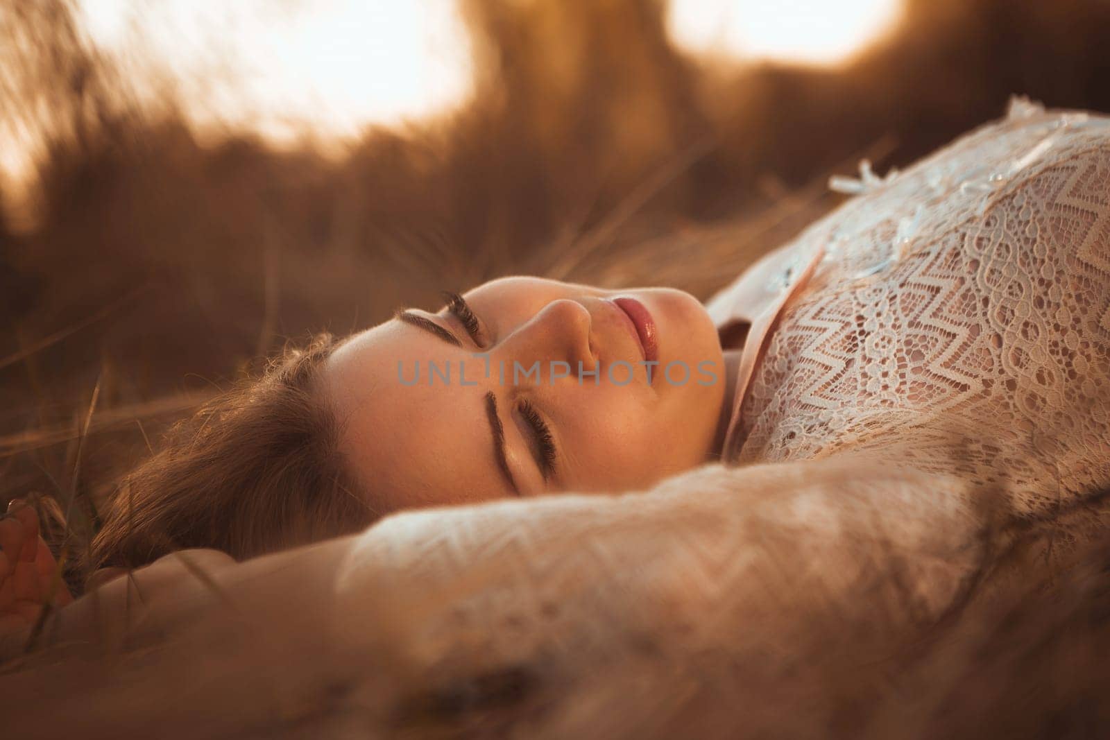 portrait of a girl lying on a field on a sunset background.