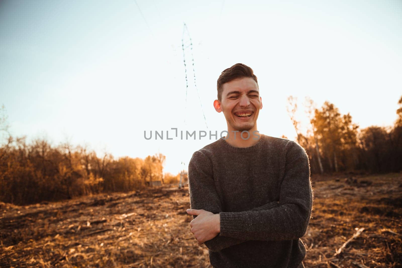 portrait of a guy in the field on a sunset background.