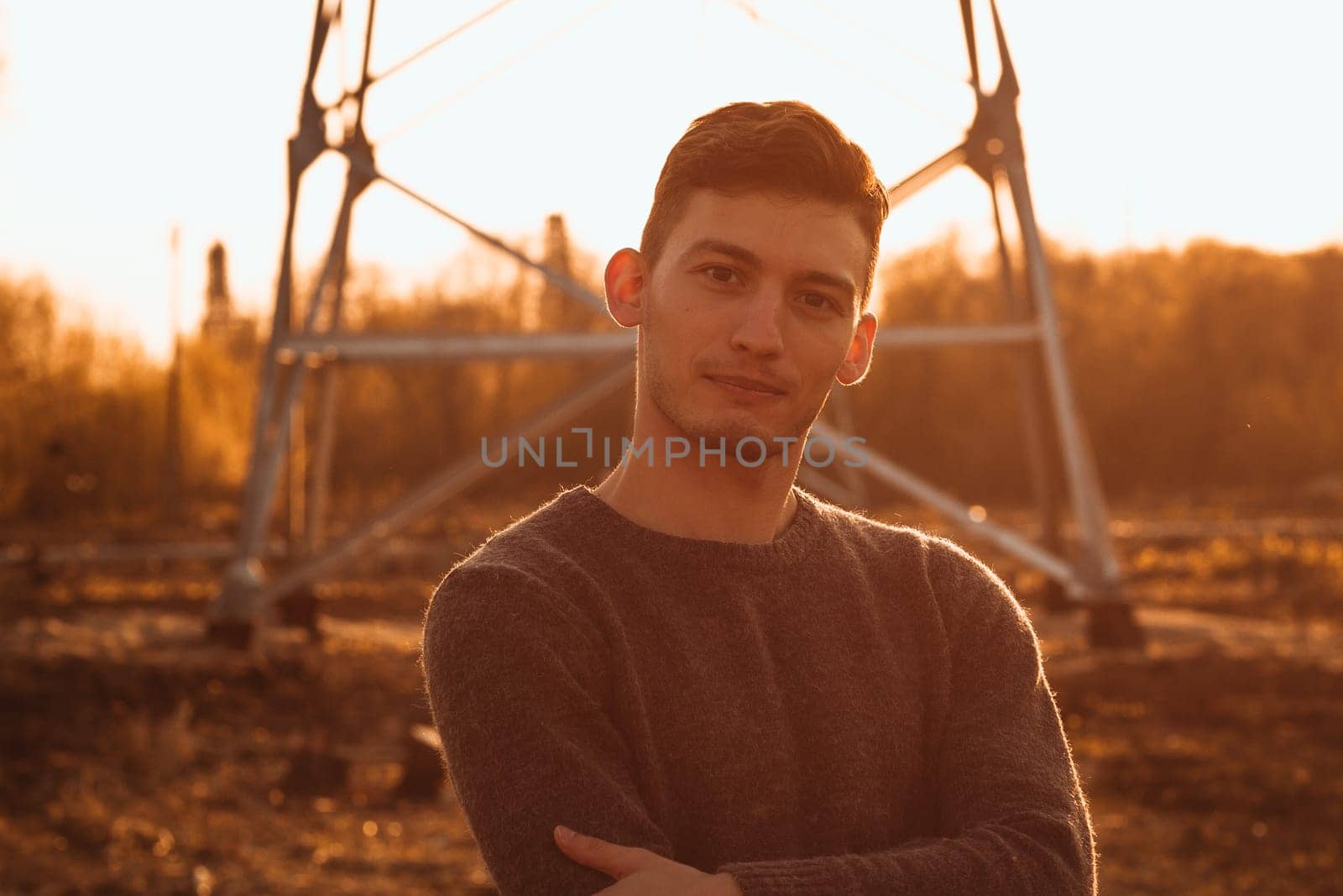 portrait of a guy in the field on a sunset background.