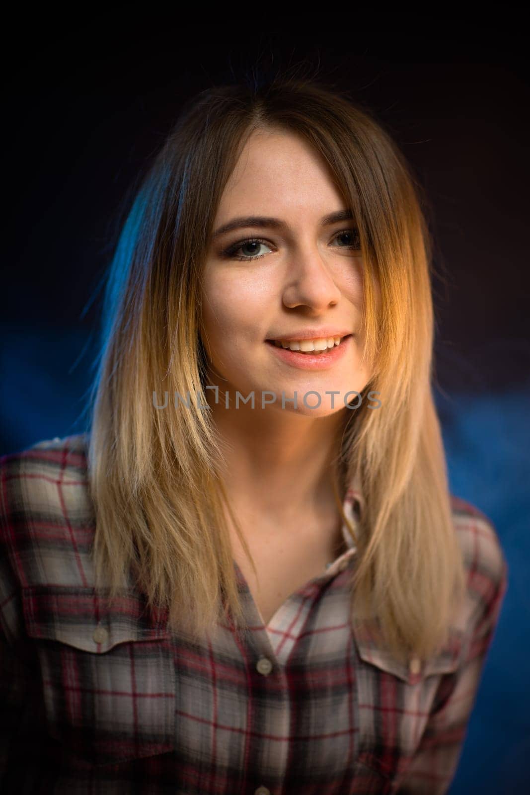 portrait smiling girl on blue background in studio.