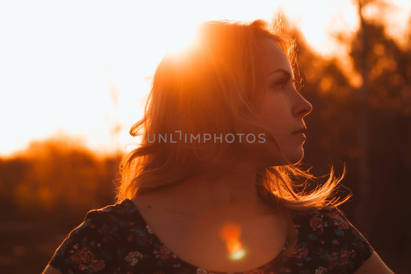 portrait of a beautiful girl in a field on a sunset background.