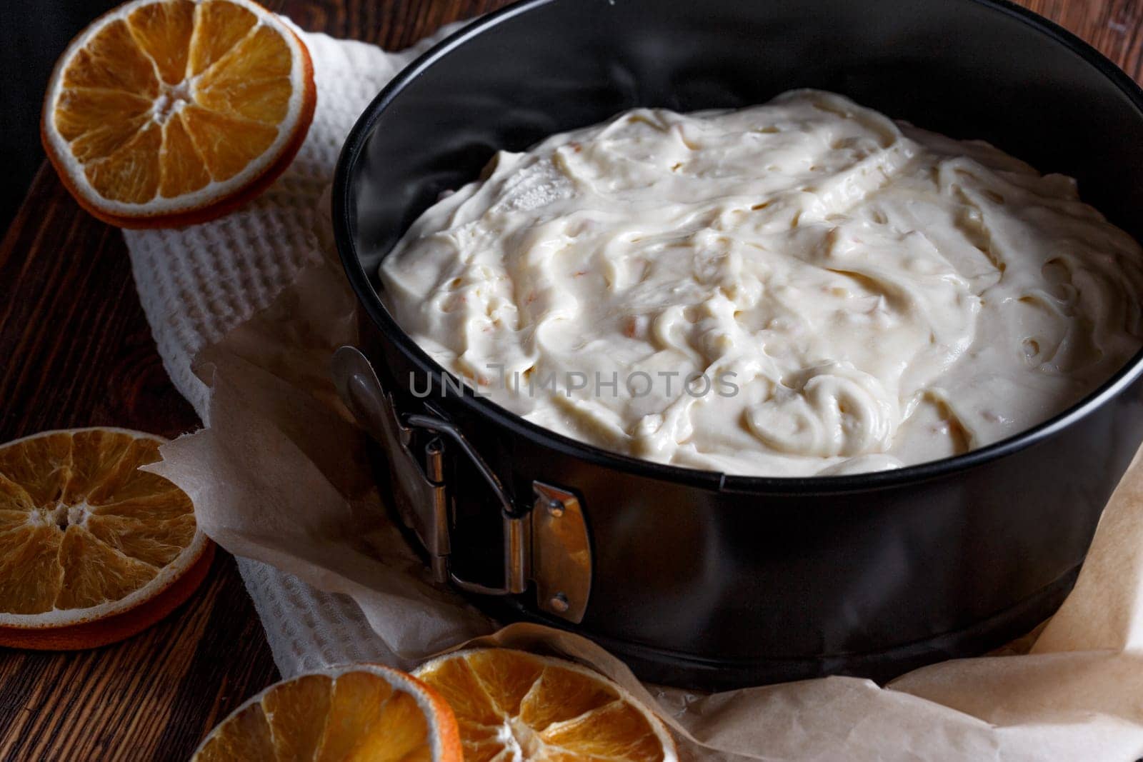Cake dough with candied orange in a baking sheet