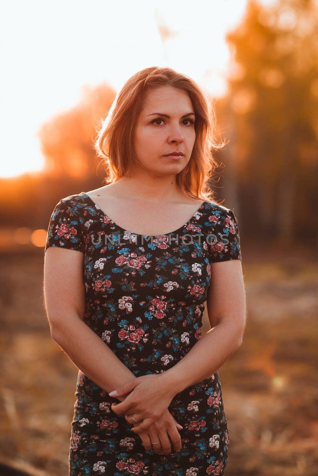 portrait of a beautiful girl in a field on a sunset background.