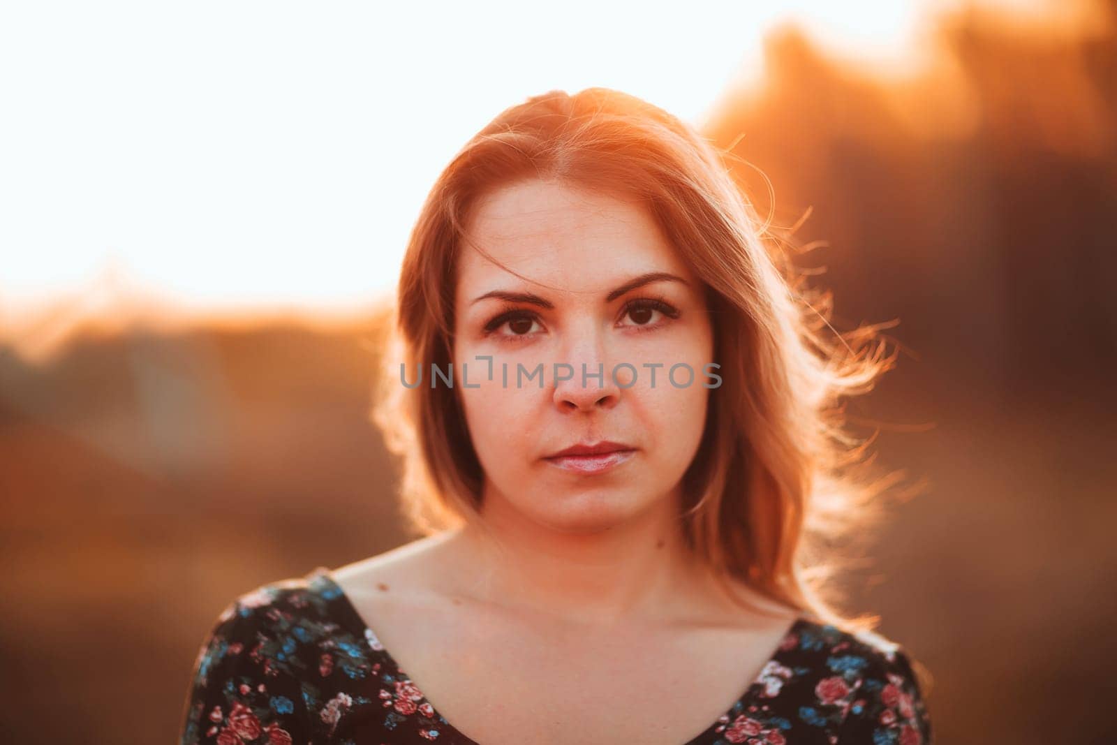portrait of a beautiful girl in a field on a sunset background.