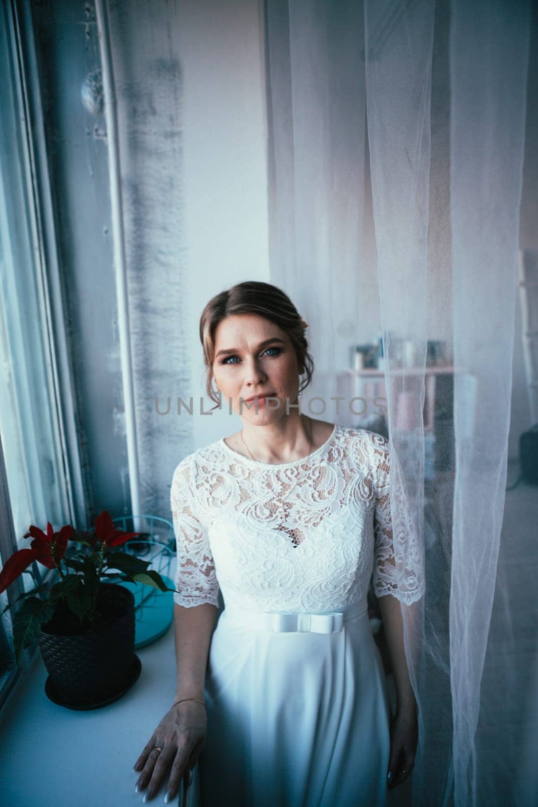portrait of a bride near a window studio.