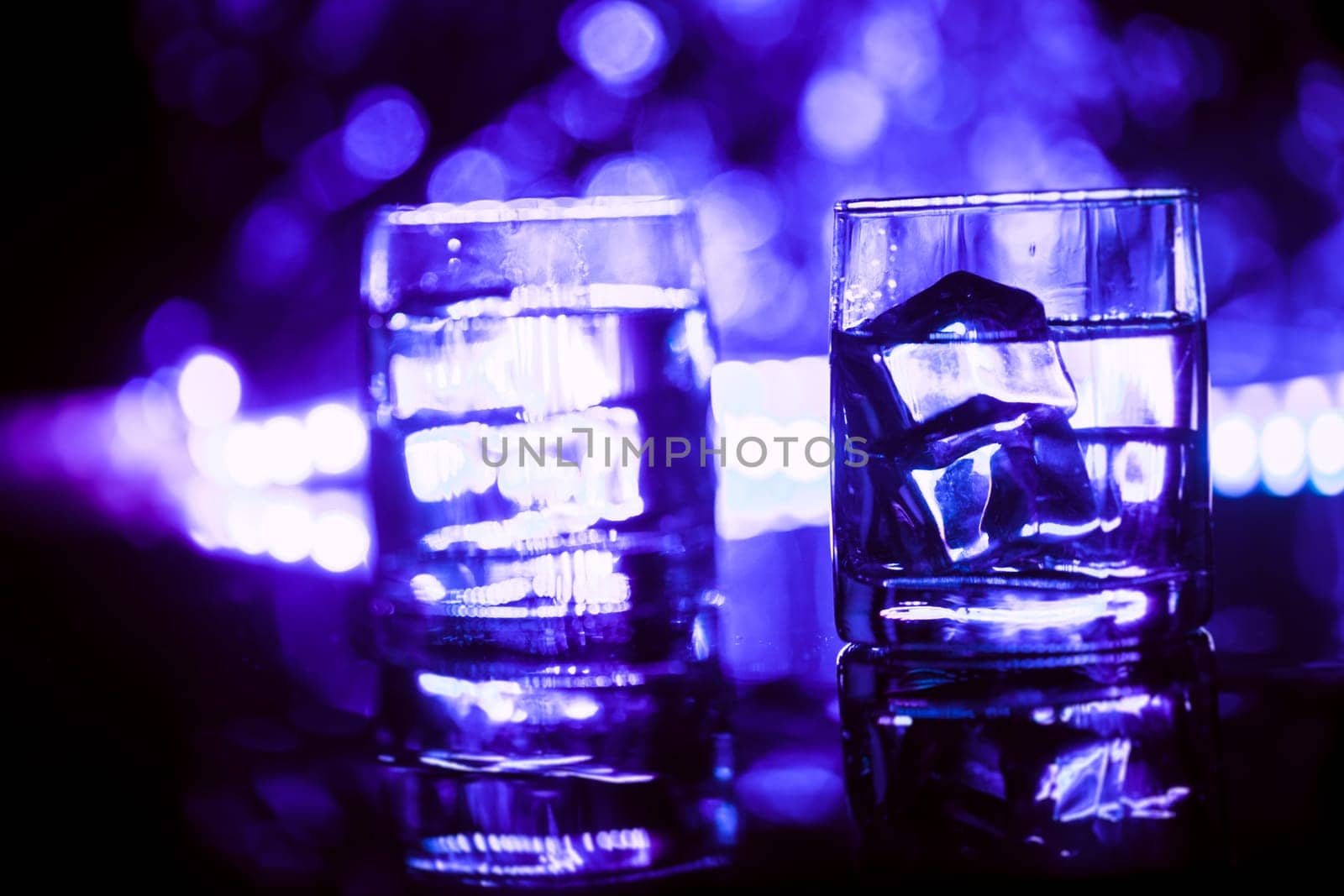 colored lighting of glasses in the night club bar.