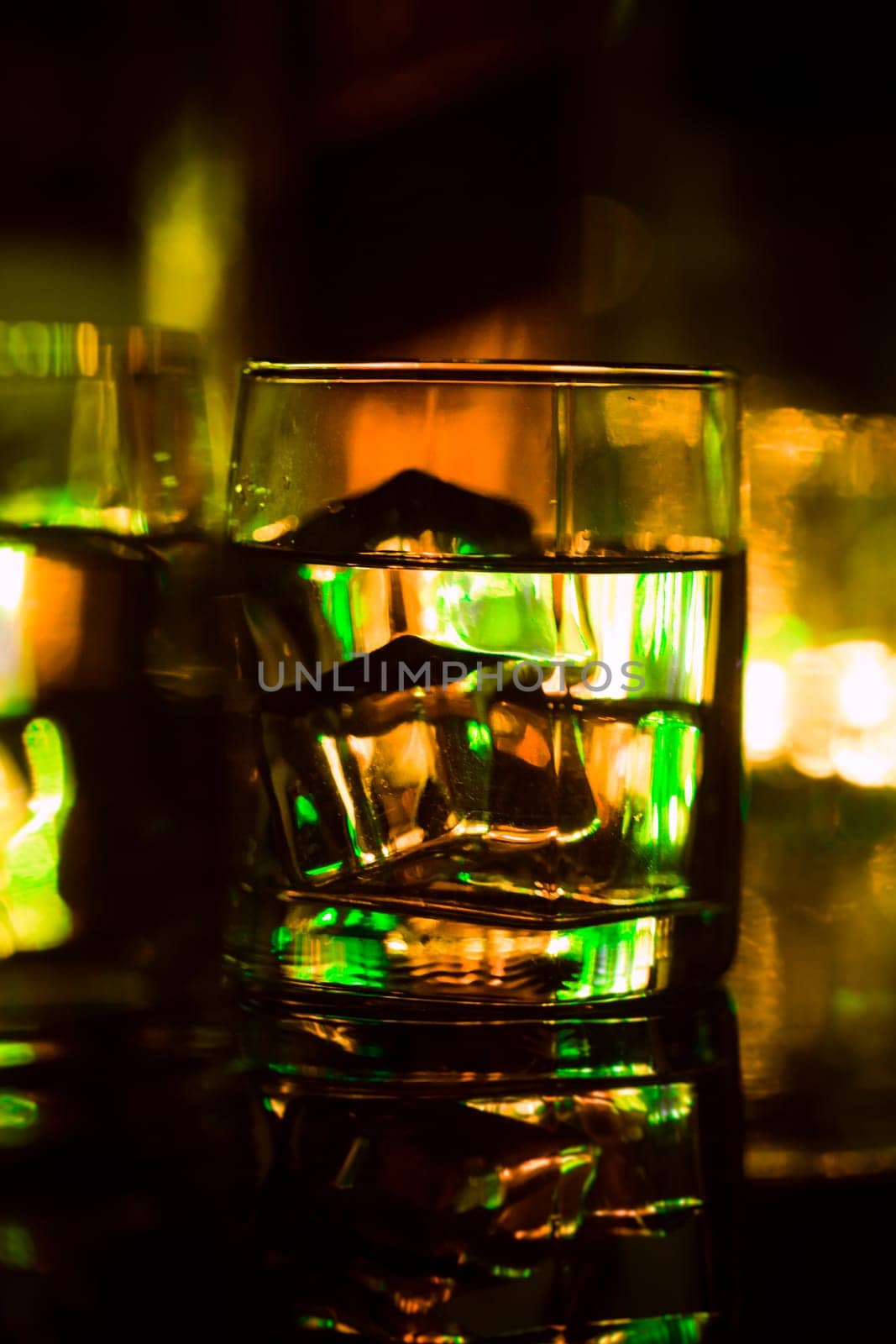 colored lighting of glasses in the night club bar.