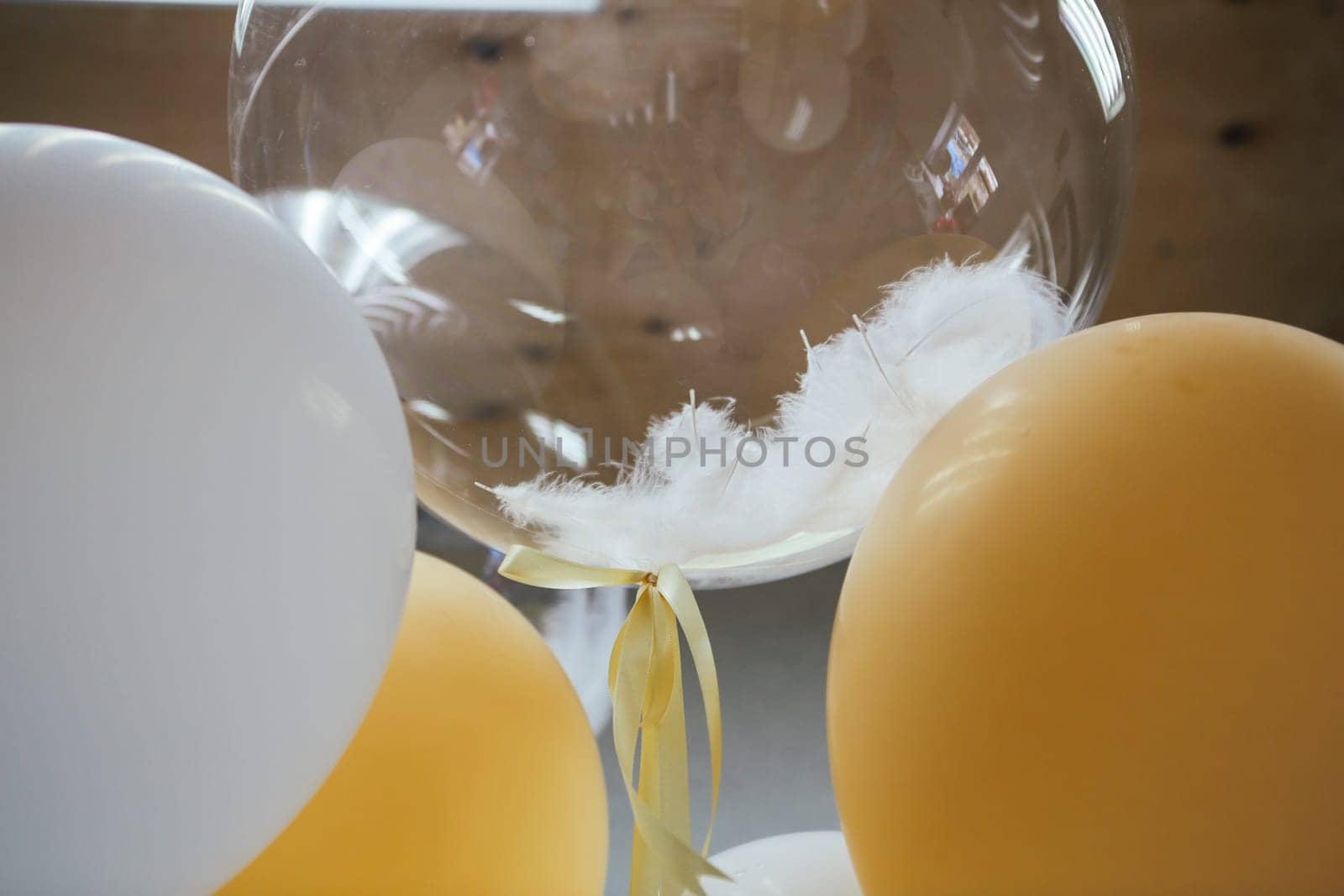 Festive balloons close up with white ostrich feather.