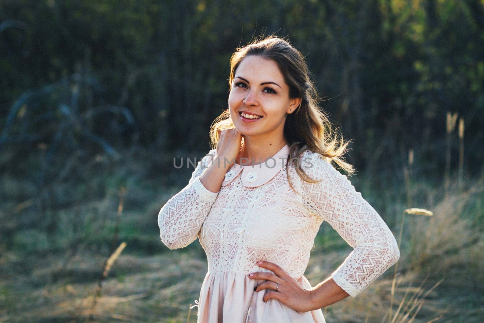 portrait of a girl in a field on a sunset background.