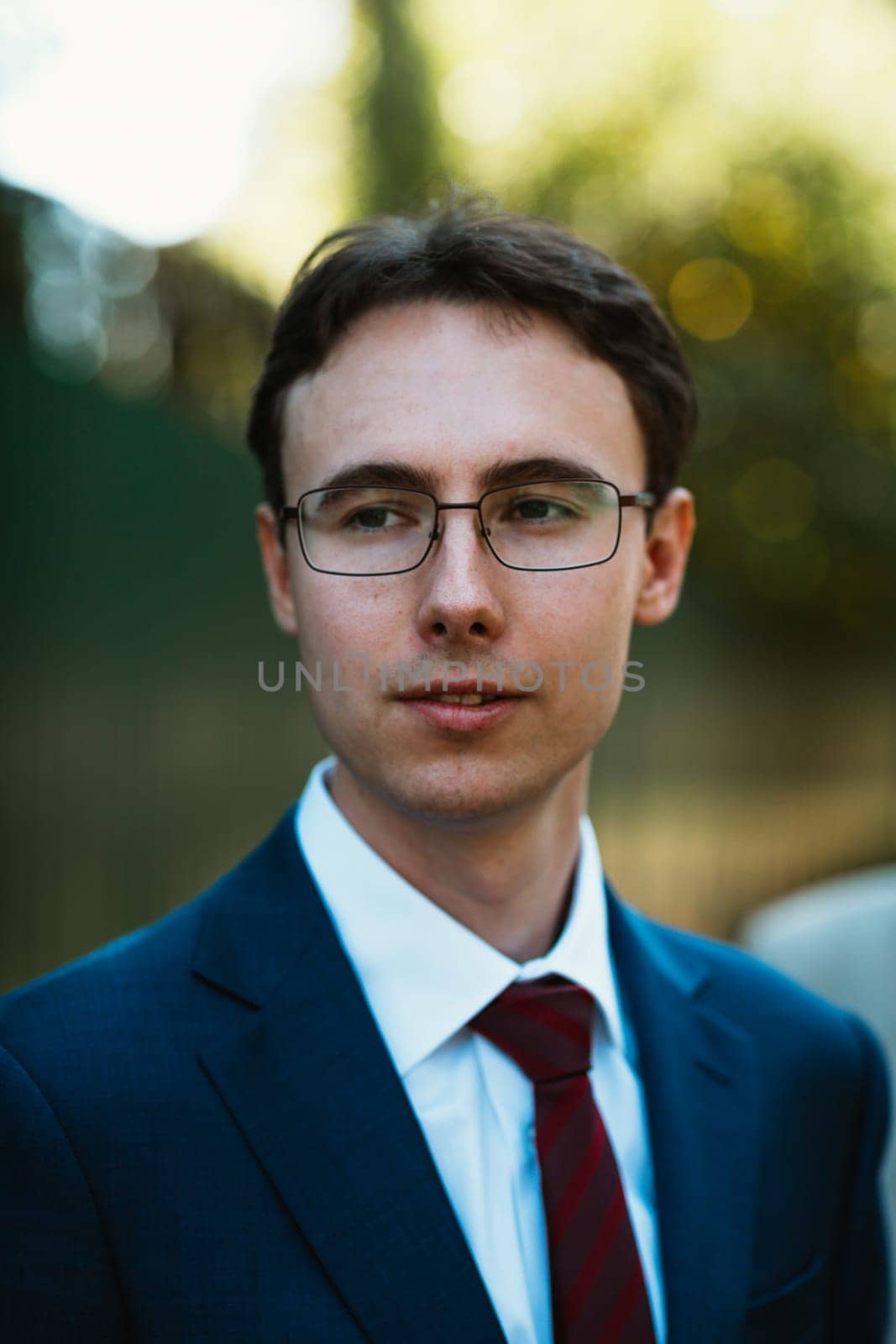 Portrait of the groom in the nature park background.