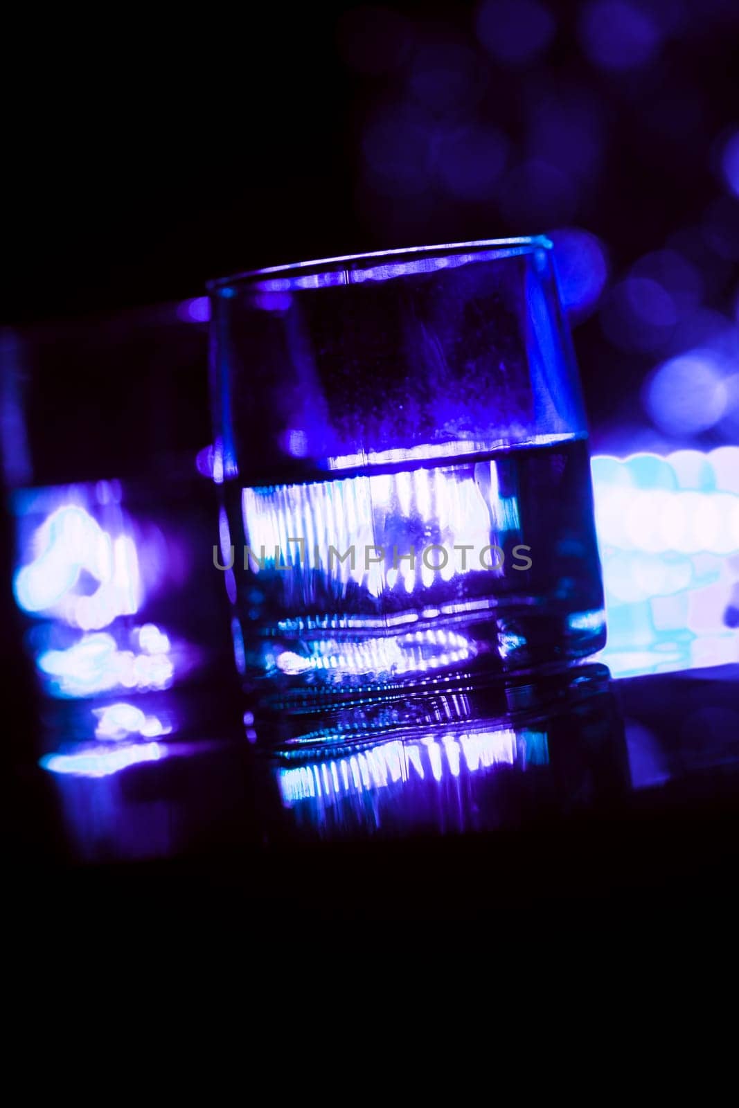 colored lighting of glasses in the night club bar.