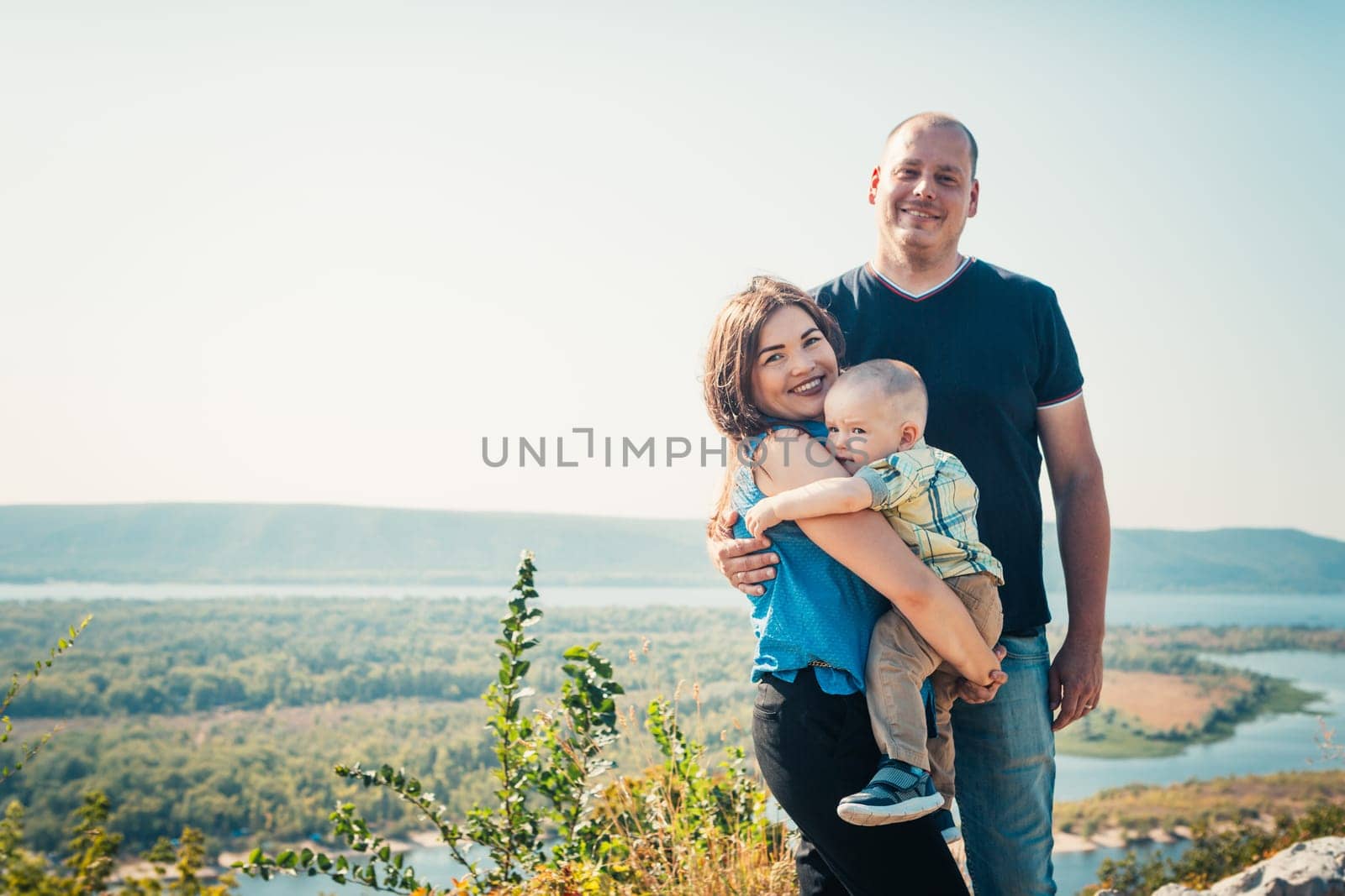 Happy family with baby son on nature background.