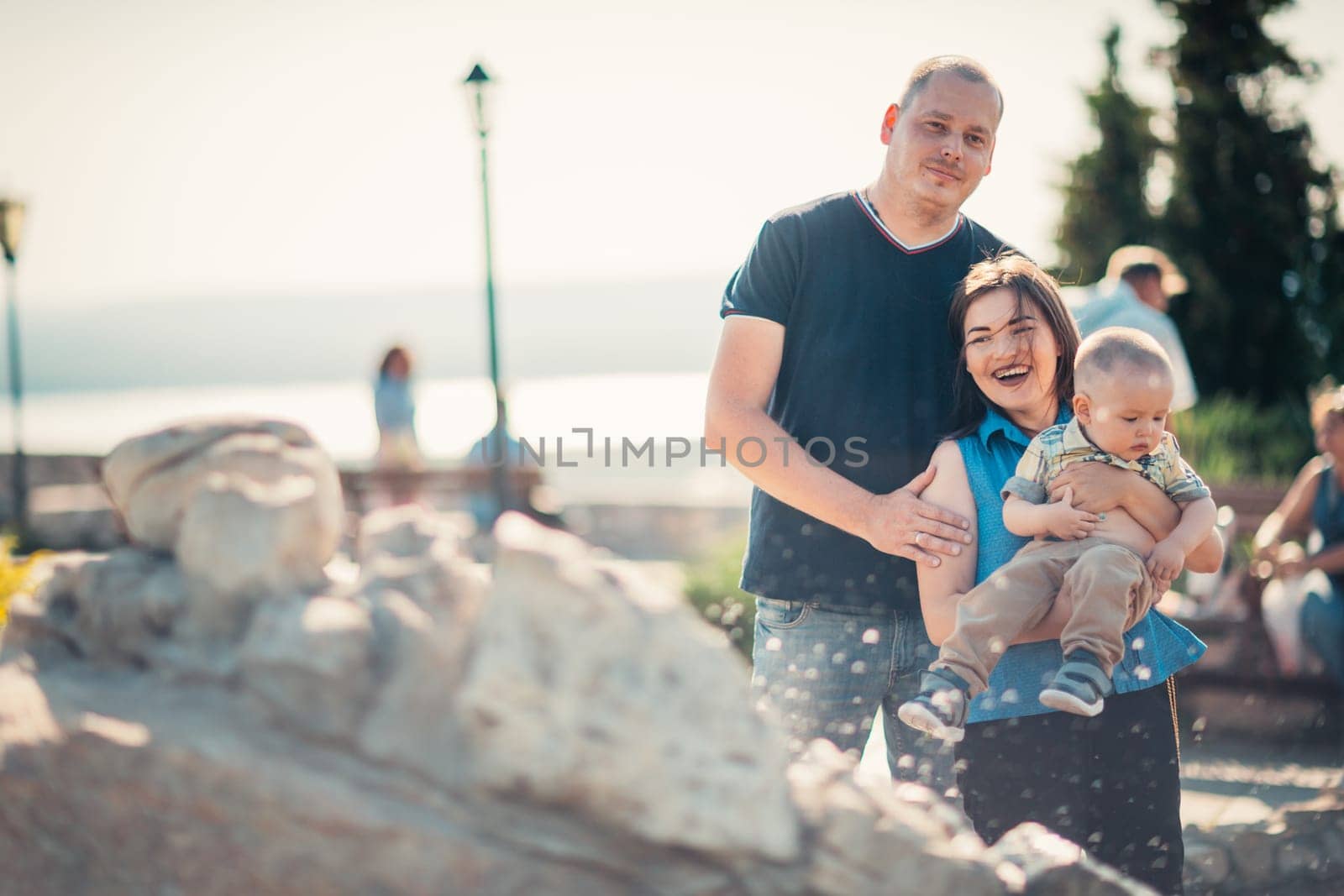 Happy family with baby near the fountain.