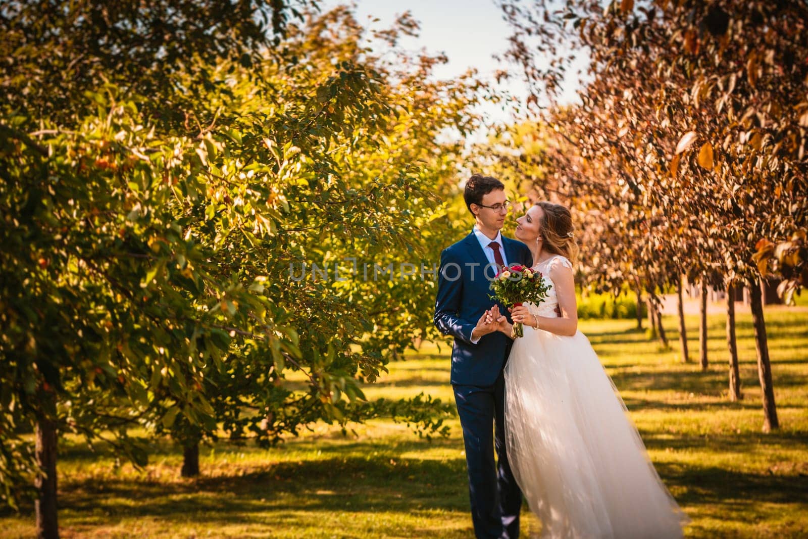 Beautiful stylish bride and groom on garden background.
