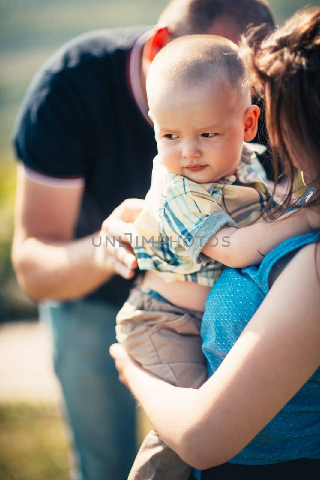 Happy family with baby son on nature background.