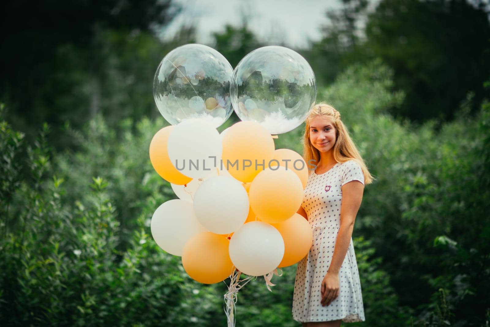 young girl with balloons on nature background.