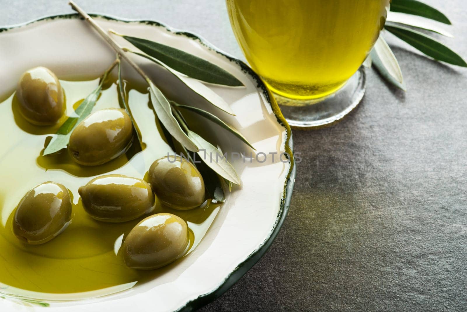 Bottle of Extra virgin healthy Olive oil with fresh olives close up