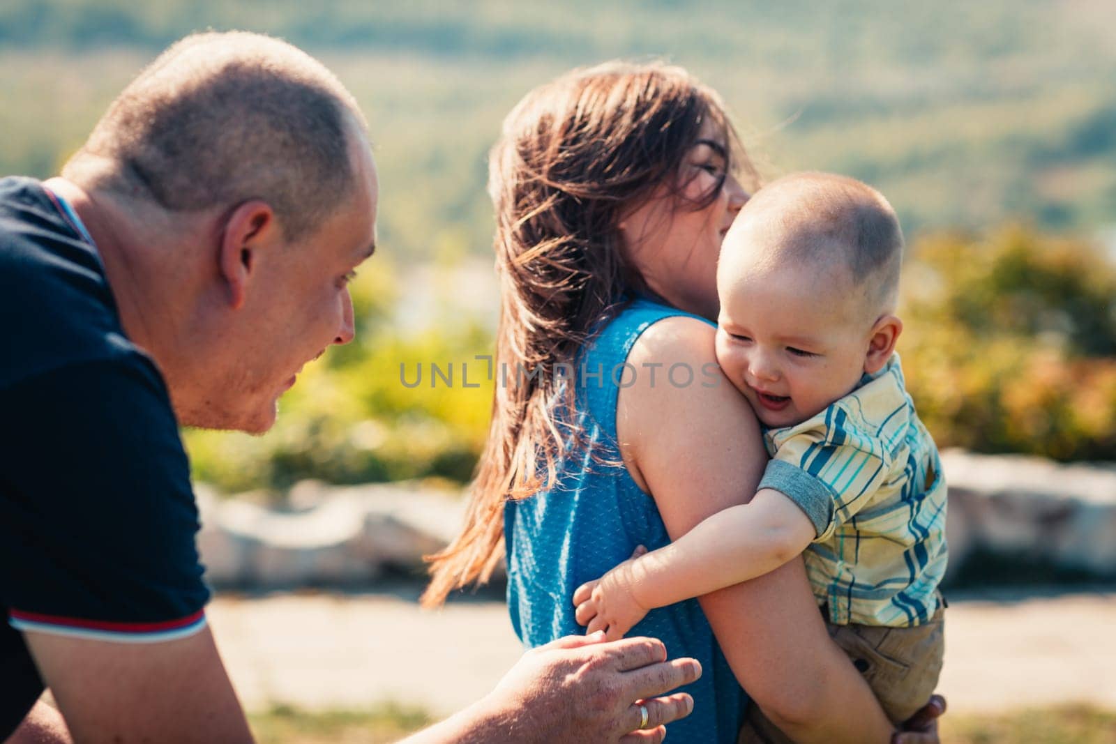 Happy family with baby son on nature background.