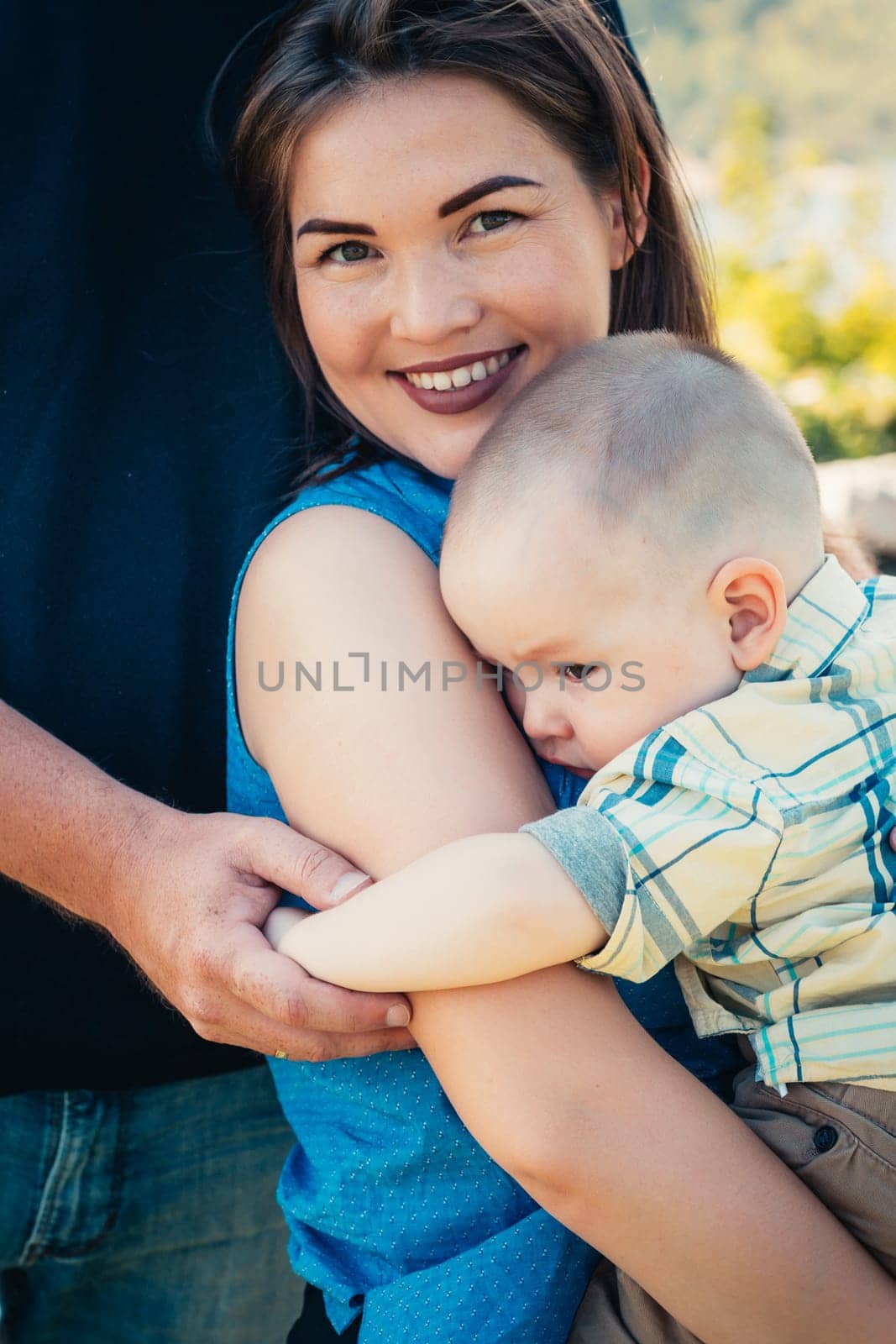 Happy family with baby son on nature background.