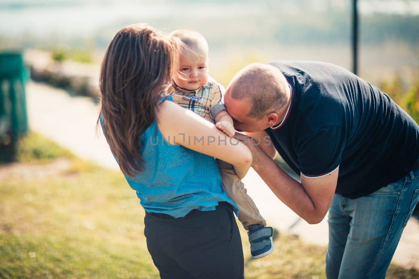 Happy family with baby son on nature background.