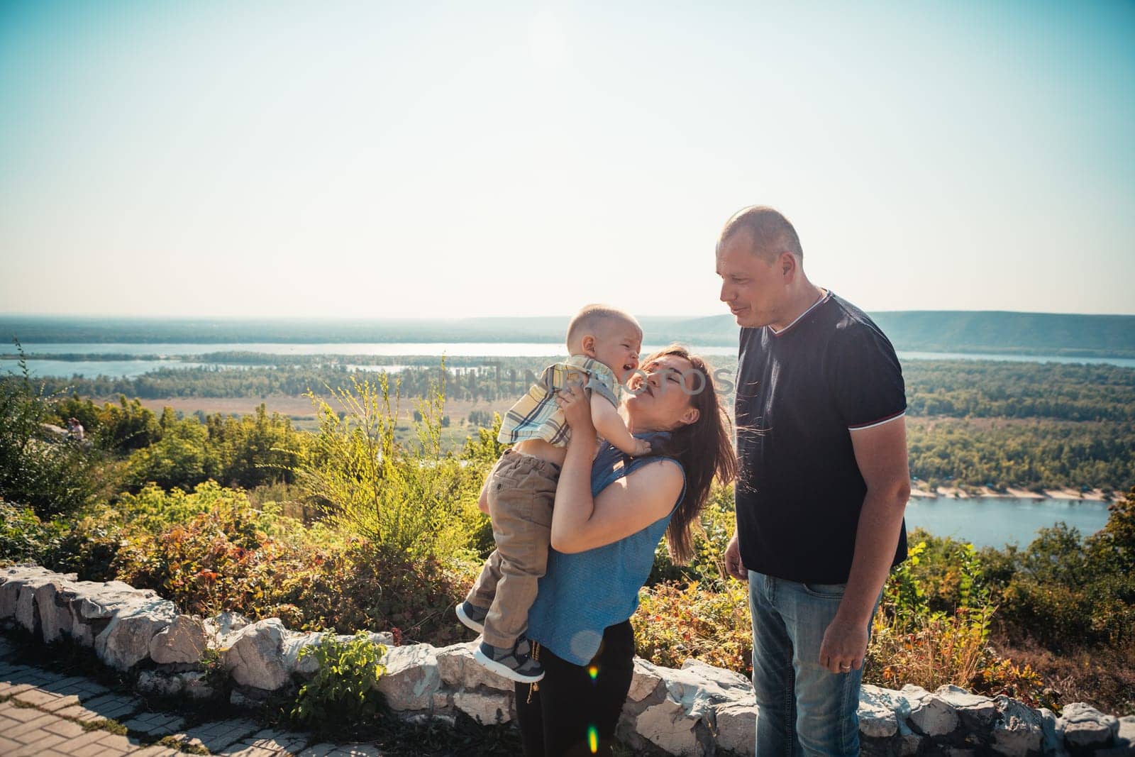 Happy family with baby son on nature background.
