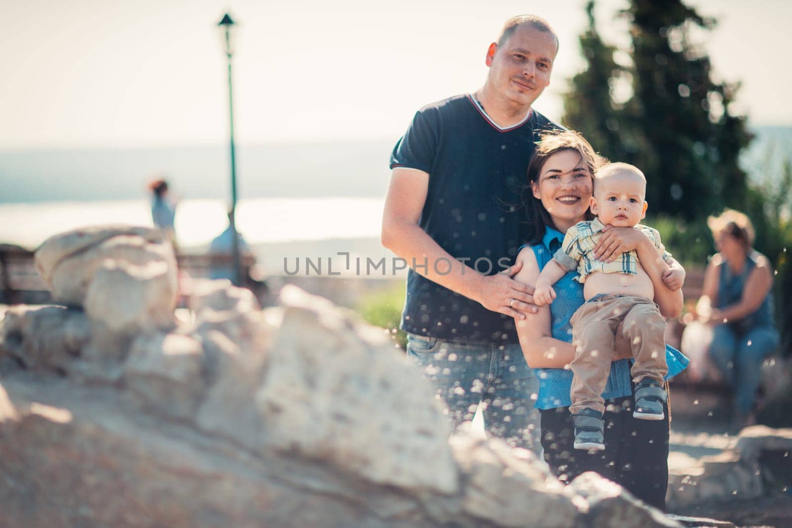 Happy family with baby near the fountain.