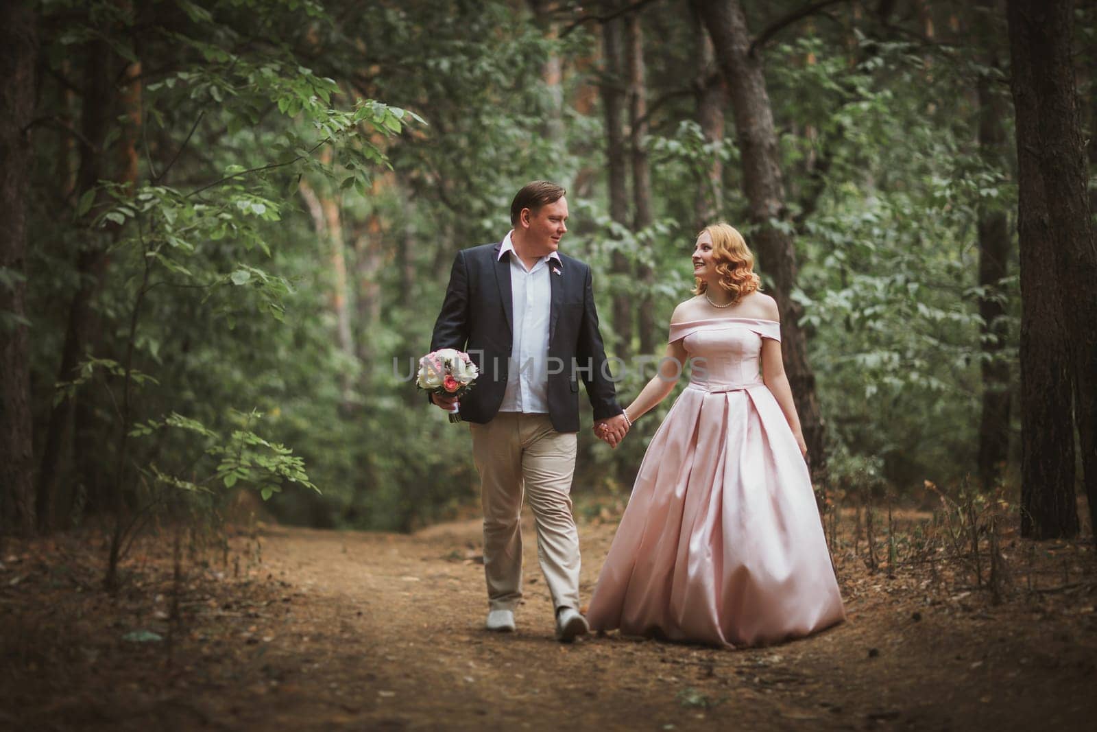 bride and groom kissing in the summer forest.