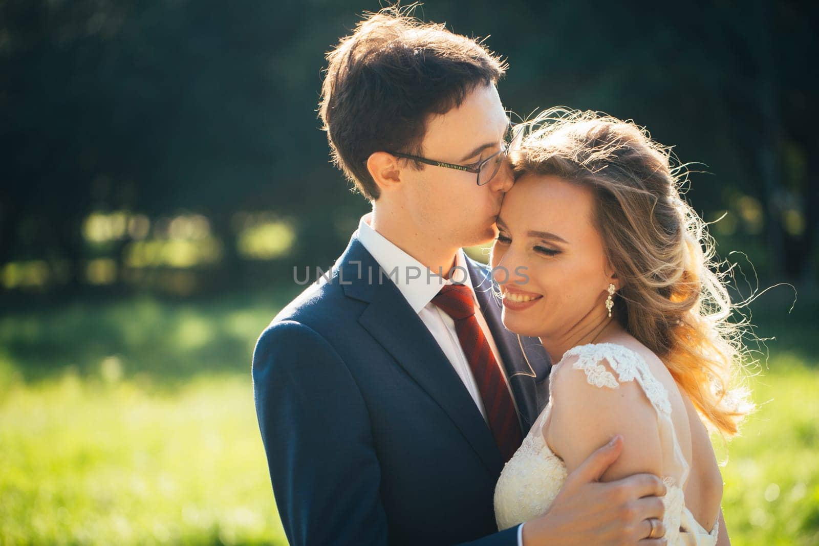 bride and groom embracing on nature background.
