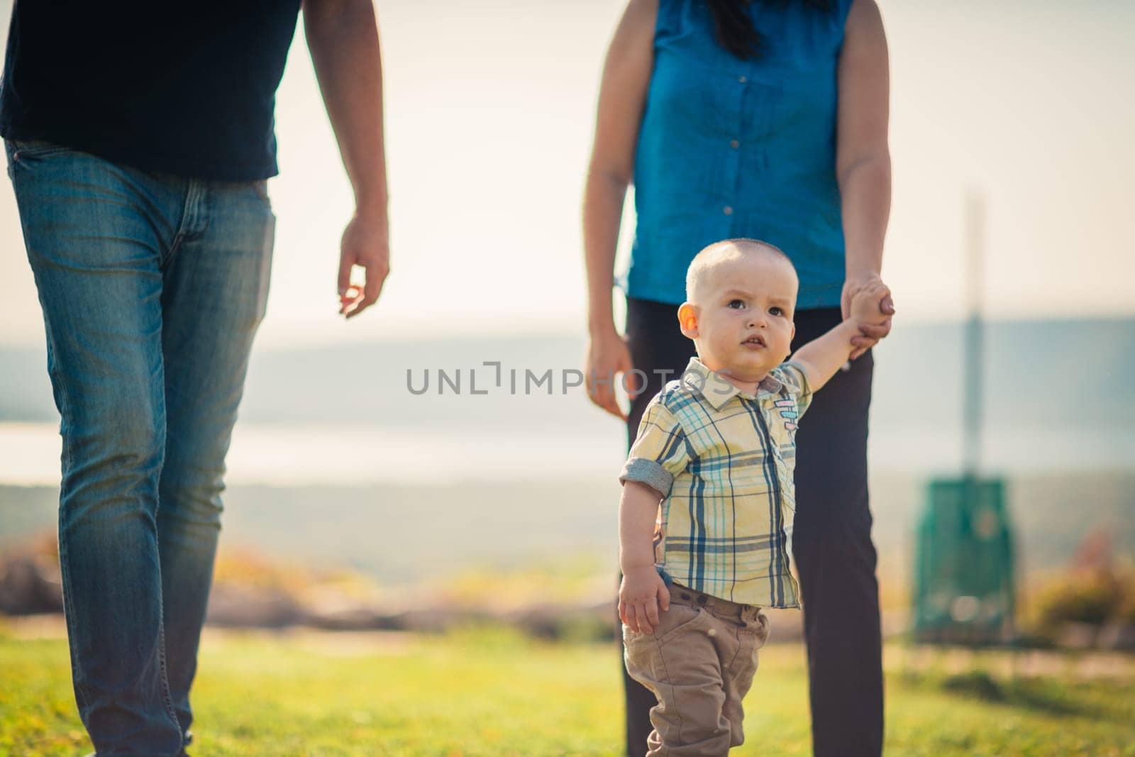 Happy family with baby on green grass.