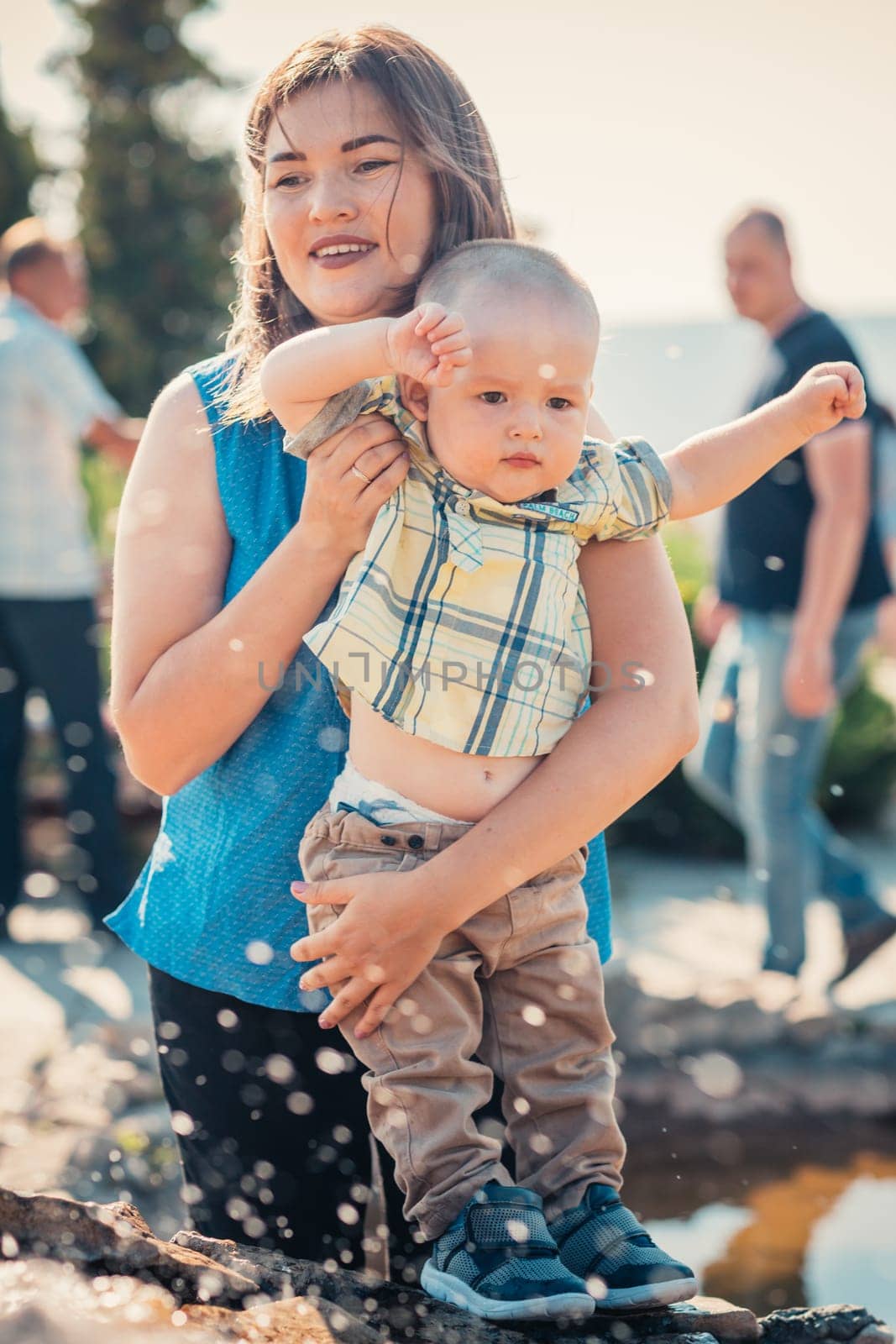 happy mother and toddler son near the fountain.