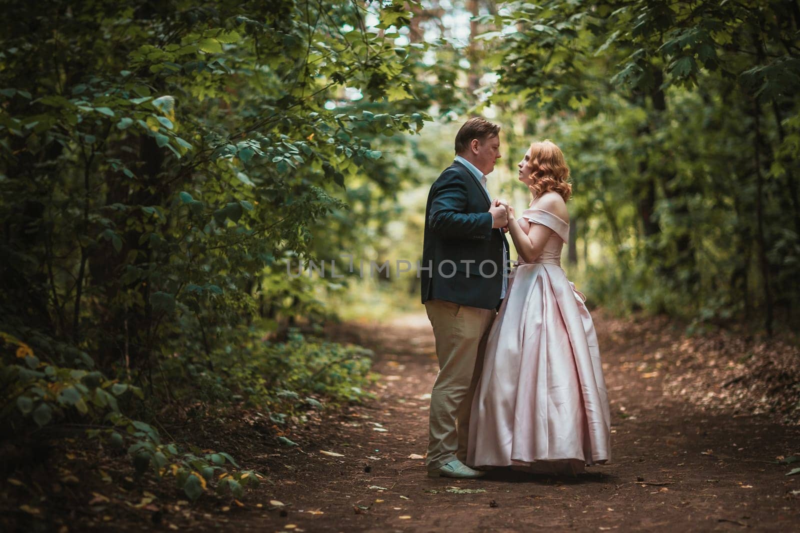 bride and groom dancing in the forest background and sunlight.