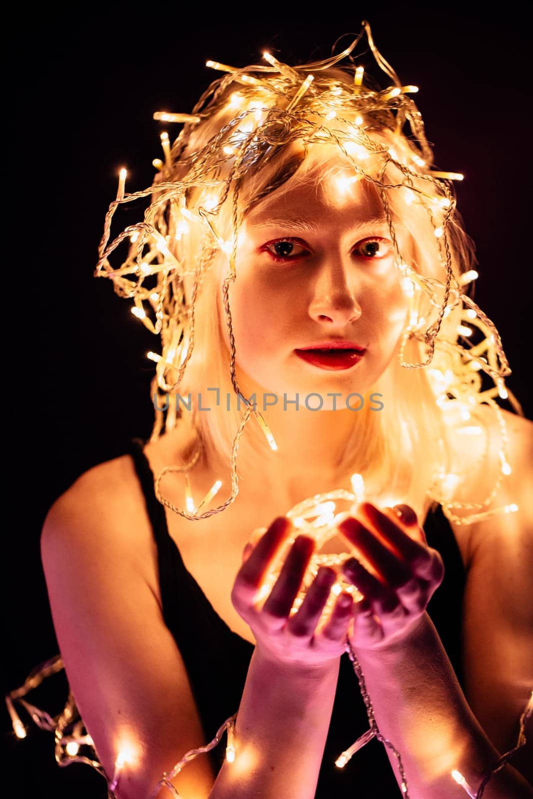 portrait of a girl with a garland on black background.
