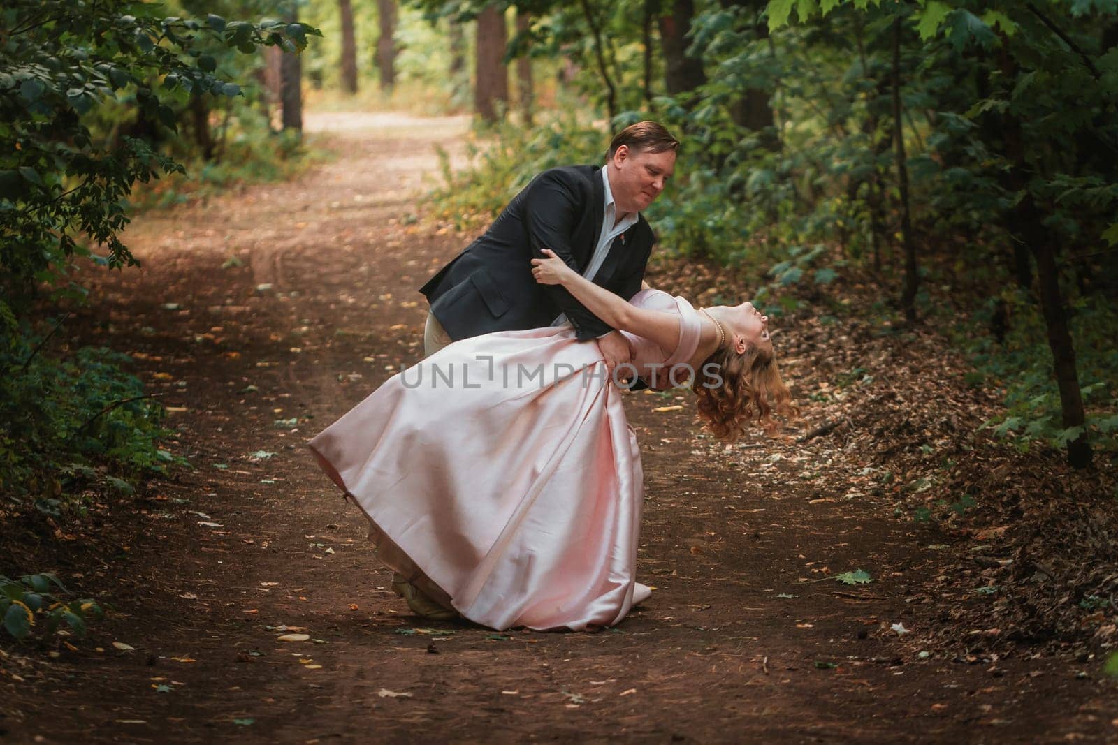 bride and groom dancing in the forest background and sunlight.