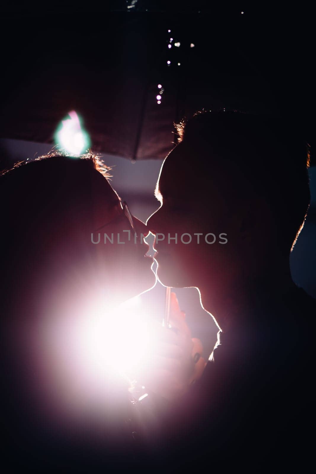 young man and woman under an umbrella and rain.