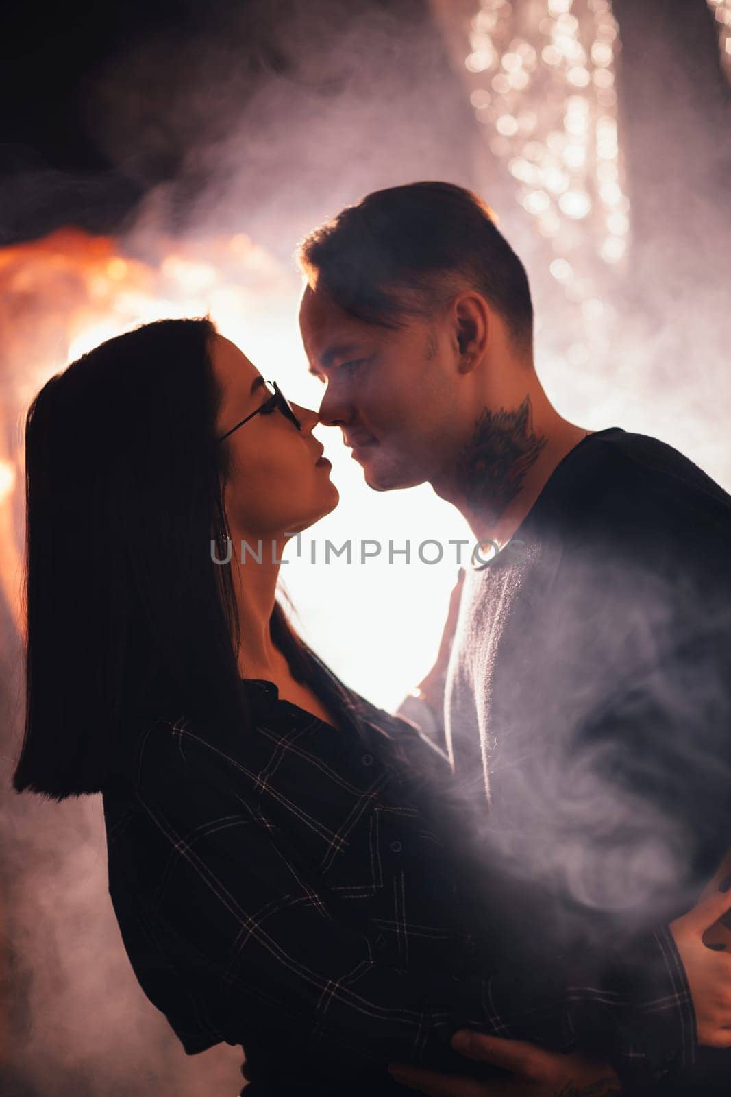 Couple in fashionable clothes on a shiny background.