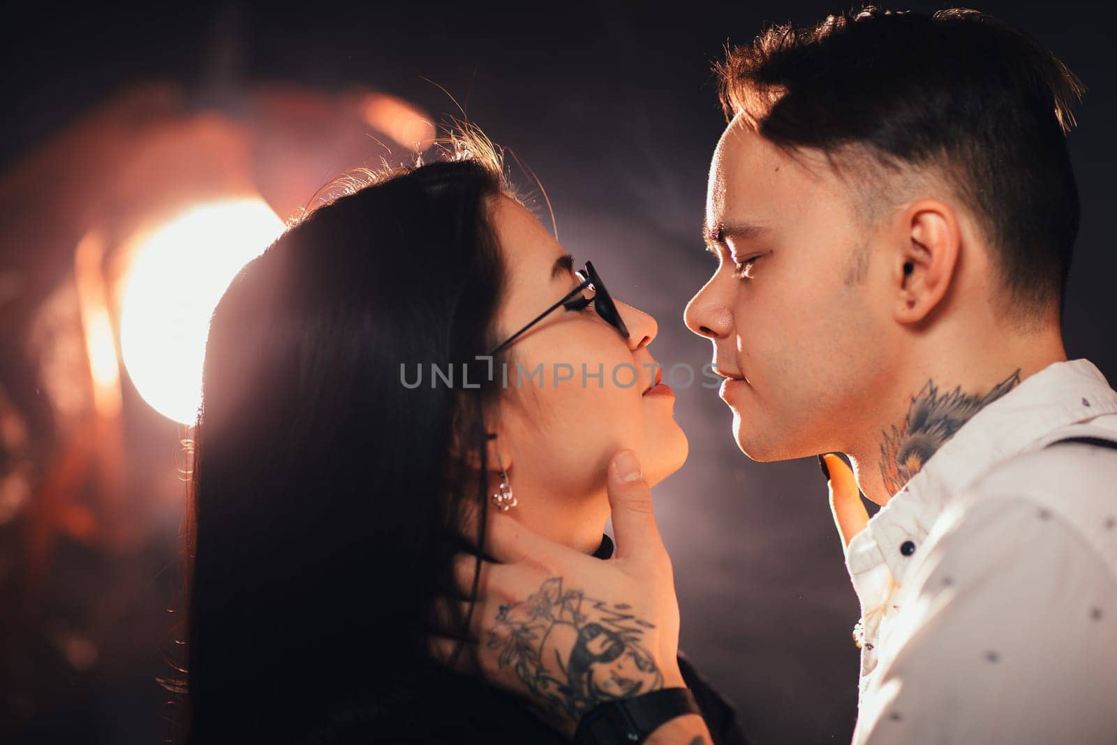 portrait couple in fashionable clothes on a dark smoky background.