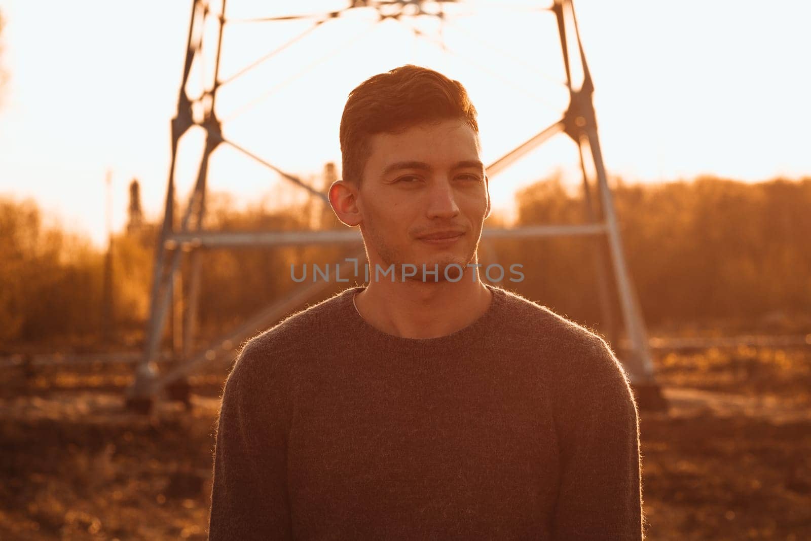 portrait of a guy in the field on a sunset background.