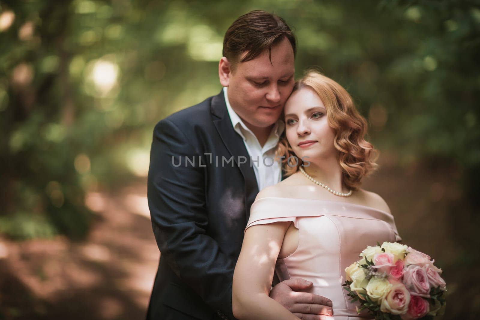 bride and groom dancing in the forest background and sunlight.