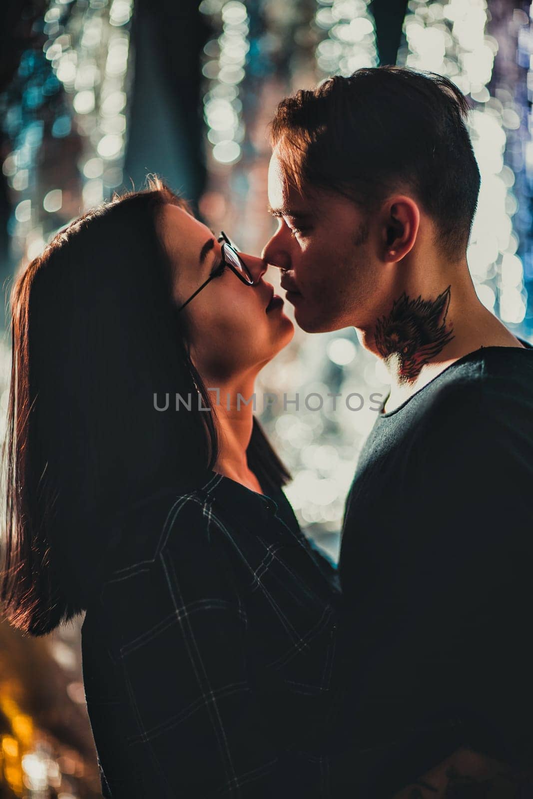 Couple in fashionable clothes on a shiny background.