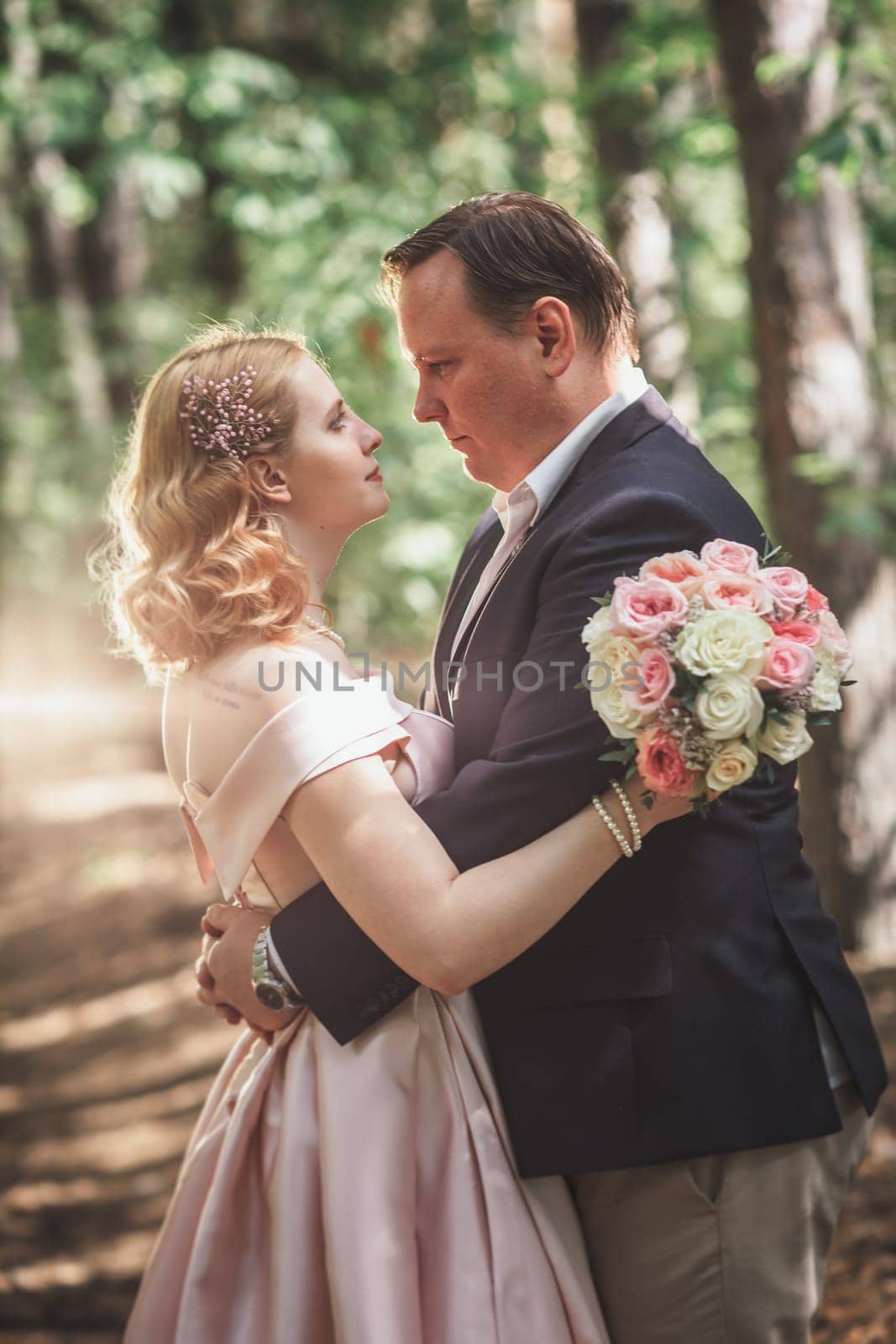 bride and groom on the background of trees and forest sun.