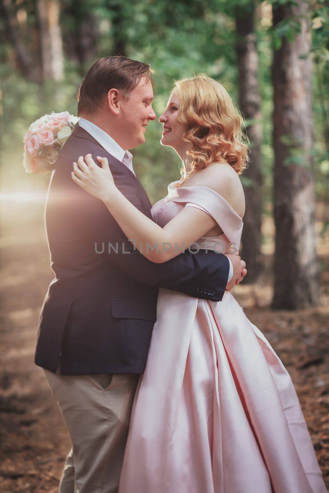 bride and groom on the background of trees and forest sun.